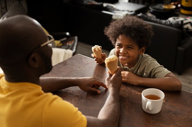 Padre e hijo tomando un helado juntos en la cocina