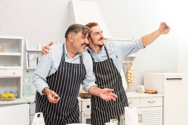 Padre e hijo tomando una selfie en cocina