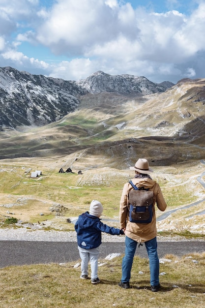 Padre e hijo viajan juntos en las montañas de otoño Durmitor Montenegro