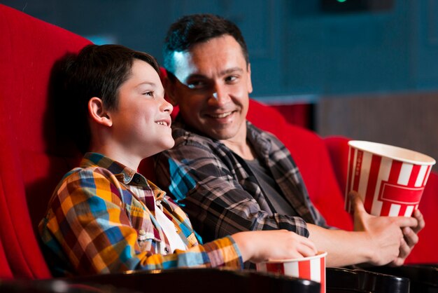 Padre e hijo viendo película en el cine