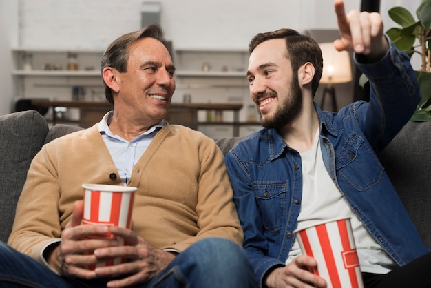 Foto gratuita padre e hijo viendo tv en la sala