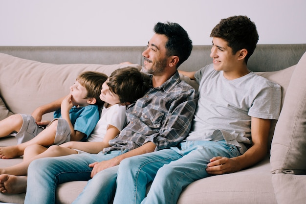 Padre e hijos en sofá en el día del padre