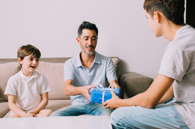 Padre e hijos en sofá en el día del padre