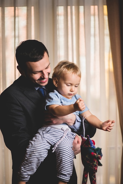 Foto gratuita padre elegante sujetando a su hijo