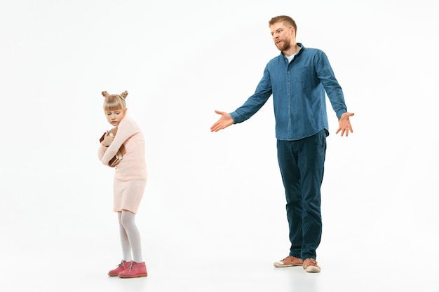 Padre enojado regañando a su hija en casa. Foto de estudio de familia emocional. Las emociones humanas, la infancia, los problemas, los conflictos, la vida doméstica, el concepto de relación