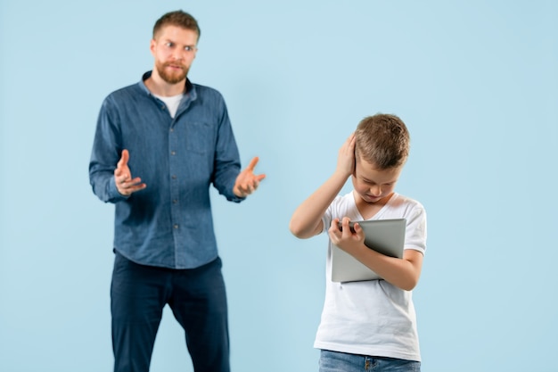 Foto gratuita padre enojado regañando a su hijo en casa