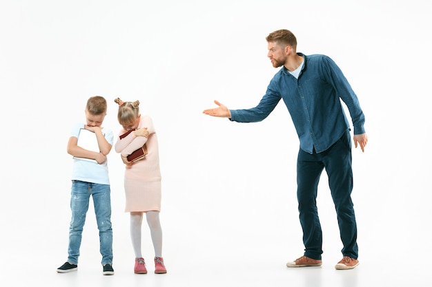 Foto gratuita padre enojado regañando a su hijo e hija en casa