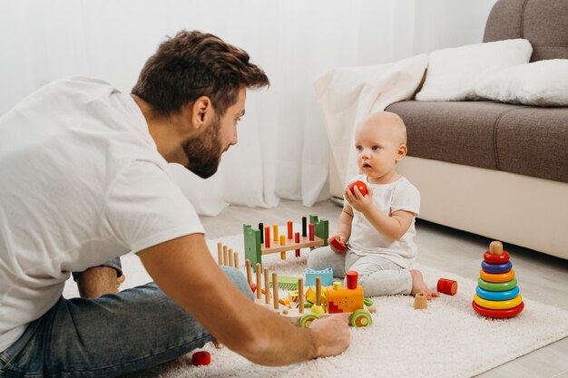 Padre enseñando a bebé a jugar con juguetes