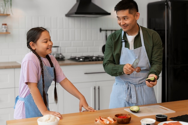 Padre enseñando a su hijo a hacer sushi