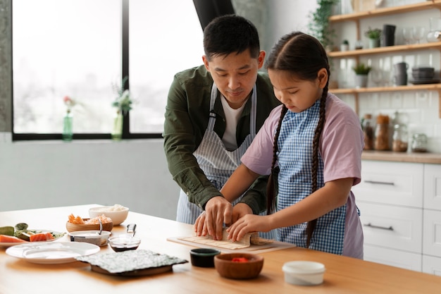 Padre enseñando a su hijo a hacer sushi