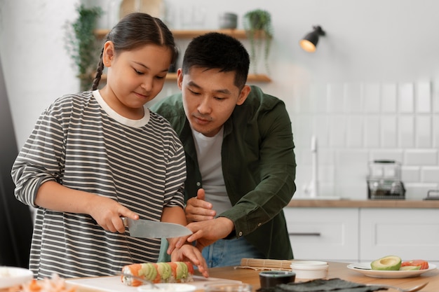 Padre enseñando a su hijo a hacer sushi