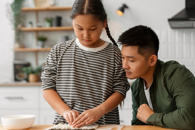 Foto gratuita padre enseñando a su hijo a hacer sushi