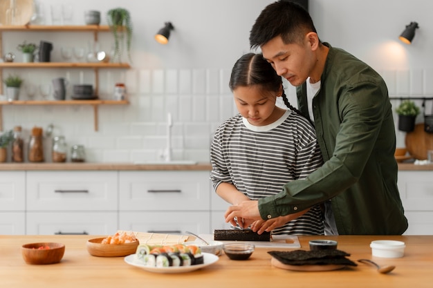 Padre enseñando a su hijo a hacer sushi