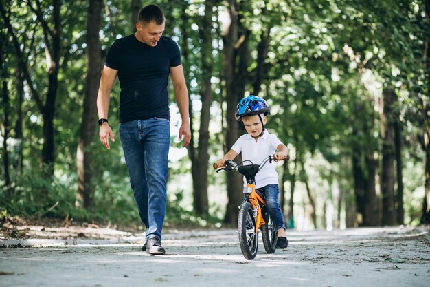 Padre enseñando a su pequeño hijo a andar en bicicleta