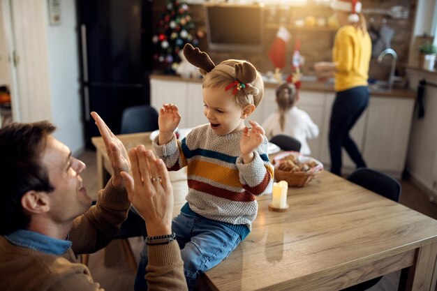 Padre feliz divirtiéndose con su hijo el día de Navidad en casa