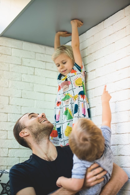 Foto gratuita padre feliz con sus hijos