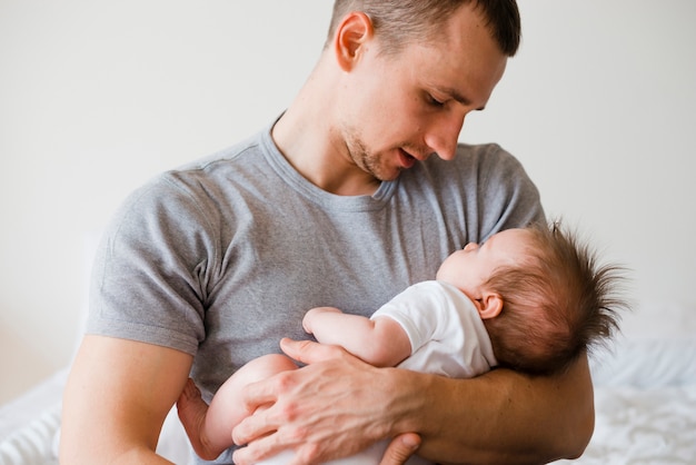 Padre guapo con pequeño bebé