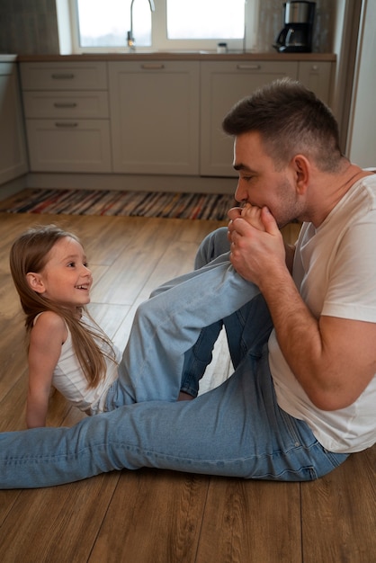 Foto gratuita padre haciendo reír a su hija haciéndole cosquillas