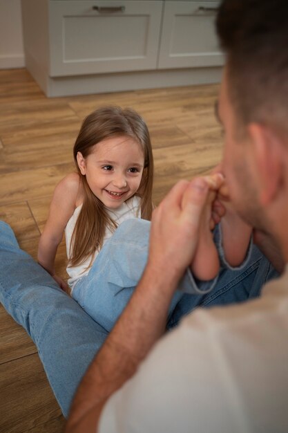 Padre haciendo reír a su hija haciéndole cosquillas