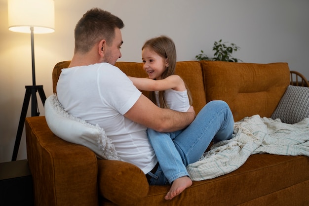 Padre haciendo reír a su hija haciéndole cosquillas