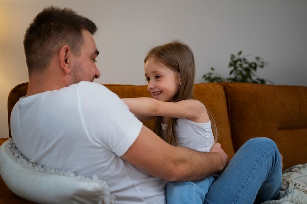 Foto gratuita padre haciendo reír a su hija haciéndole cosquillas