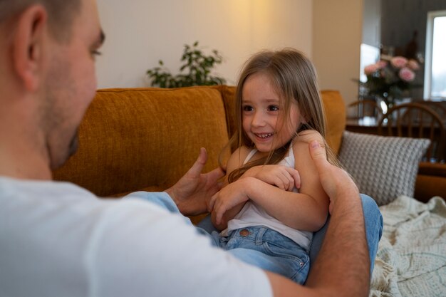 Padre haciendo reír a su hija haciéndole cosquillas