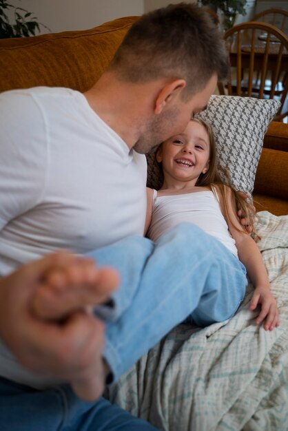 Padre haciendo reír a su hija haciéndole cosquillas