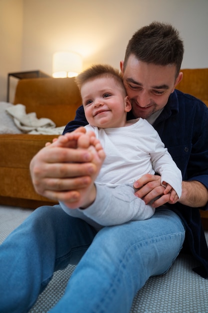 Foto gratuita padre haciendo reír a su hijo haciéndole cosquillas