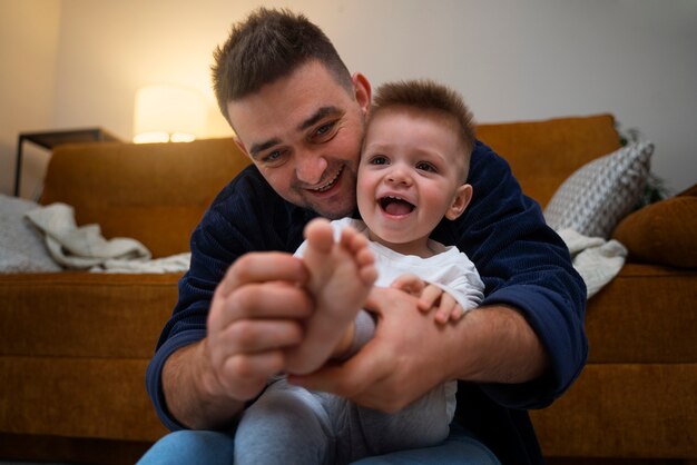 Padre haciendo reír a su hijo haciéndole cosquillas