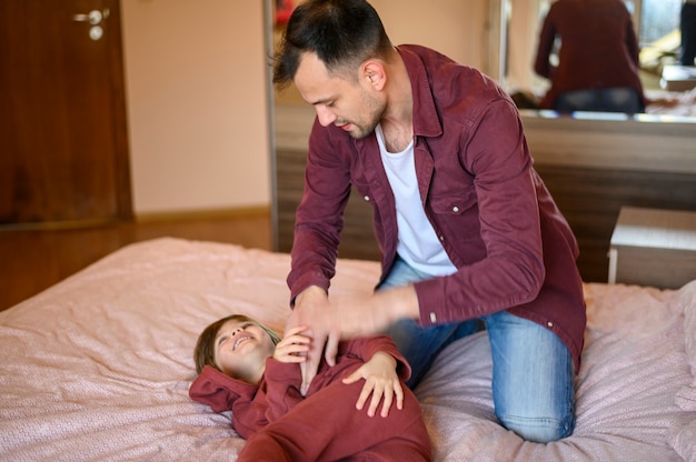 Foto gratuita padre haciéndole cosquillas a su hijo