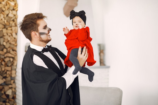 Padre con hija en disfraces y maquillaje. la familia se prepara para la celebración de halloween.