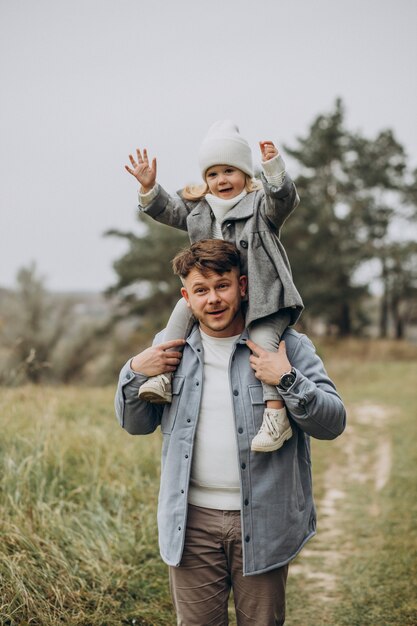 Padre con hija pequeña juntos en clima otoñal divirtiéndose