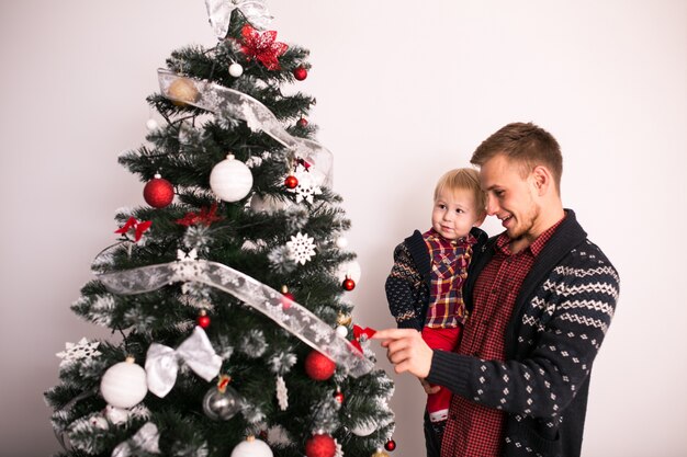 Padre con hijo junto al árbol de navidad
