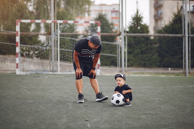 Foto gratuita padre con hijo pequeño jugando al fútbol