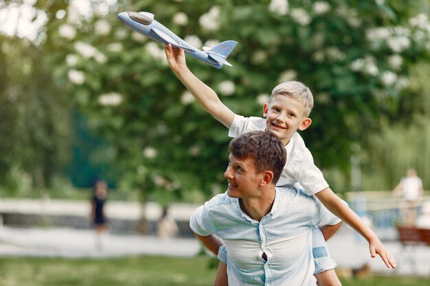 Padre con hijo pequeño jugando con avión de juguete