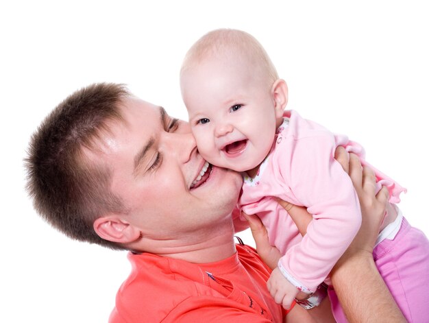 Padre joven feliz con sonrisa atractiva sosteniendo a su bebé en