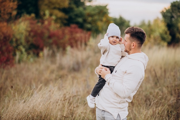 Padre joven con hijo pequeño en el campo