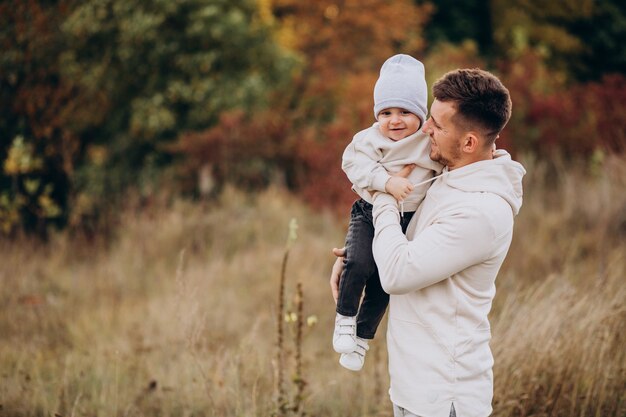 Padre joven con hijo pequeño en el campo