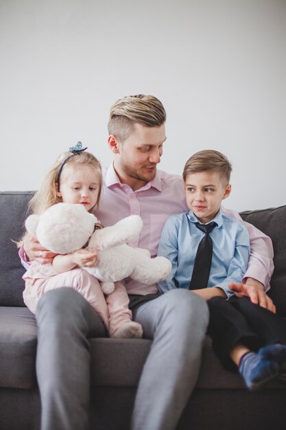 Padre joven sentado con sus hijos