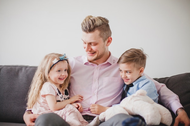 Padre joven sentado con sus hijos