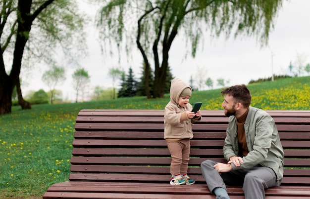 Foto gratuita padre joven con su bebé al aire libre