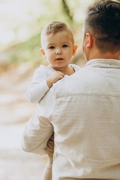 Foto gratuita padre joven con su hijo en el bosque