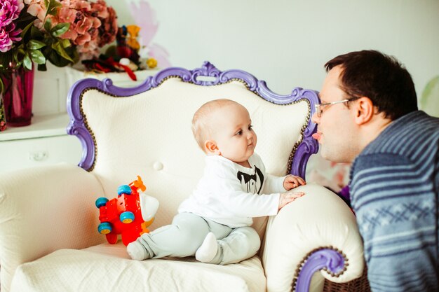 Padre juega con el pequeño hijo en un esmoquin