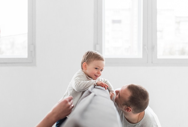 Padre jugando con bebé feliz en casa