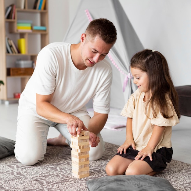 Foto gratuita padre jugando un juego de madera con su hija