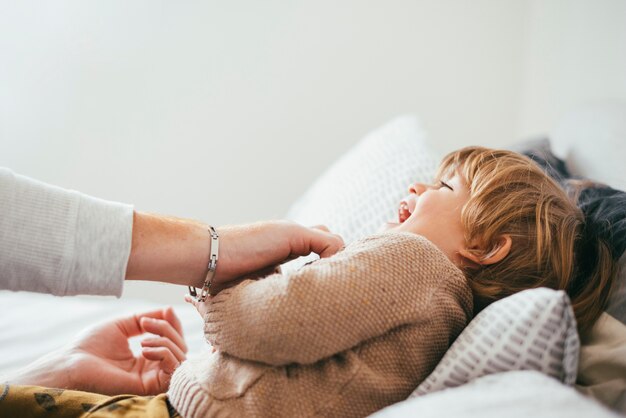 Padre jugando con el niño en la cama