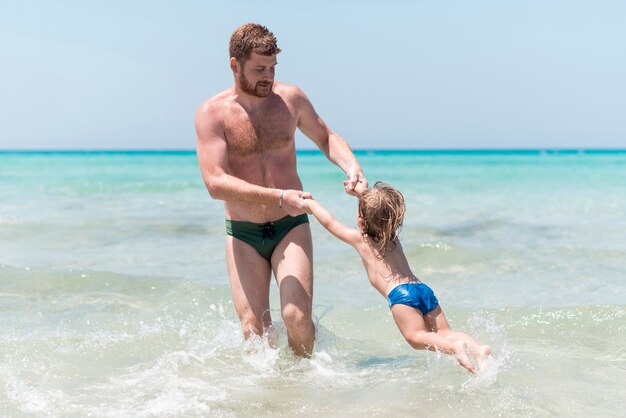 Padre jugando con el niño en el mar