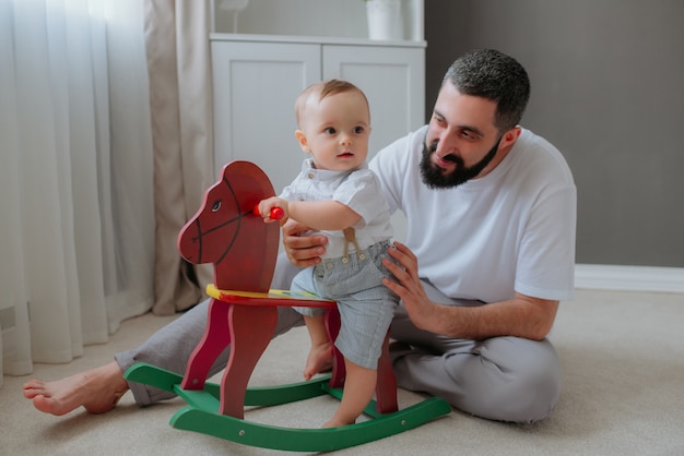 Padre jugando con su hijo en la habitación.