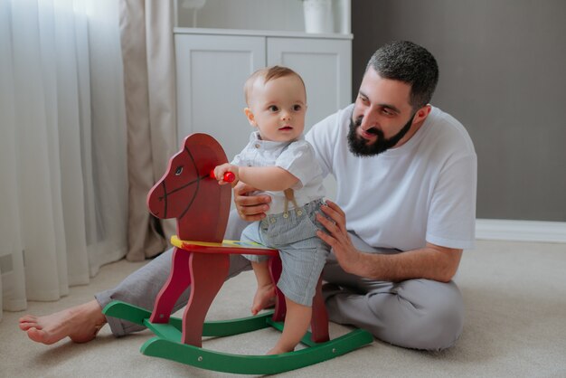 Padre jugando con su hijo en la habitación.