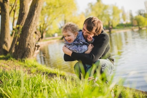 Foto gratuita padre jugando con su hijo junto al lago